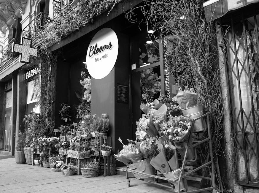 The storefront of Bloom, a flower shop near Balham station, decorated with an array of fresh floral arrangements and bouquets. Outside, various vibrant flower bundles are displayed on wooden crates an